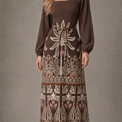 vestido largo de Chiara Studio en color marrón chocolate, de estilo bohemio chic, con escote cuadrado, mangas largas abullonadas y una llamativa estampa botánica y simétrica en tonos beige y rosa suave sobre la falda.